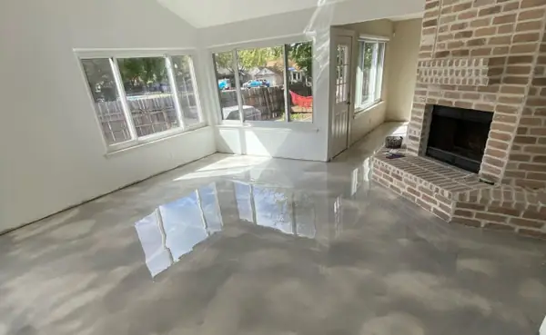 Glossy gray floor in a living room with a brick fireplace