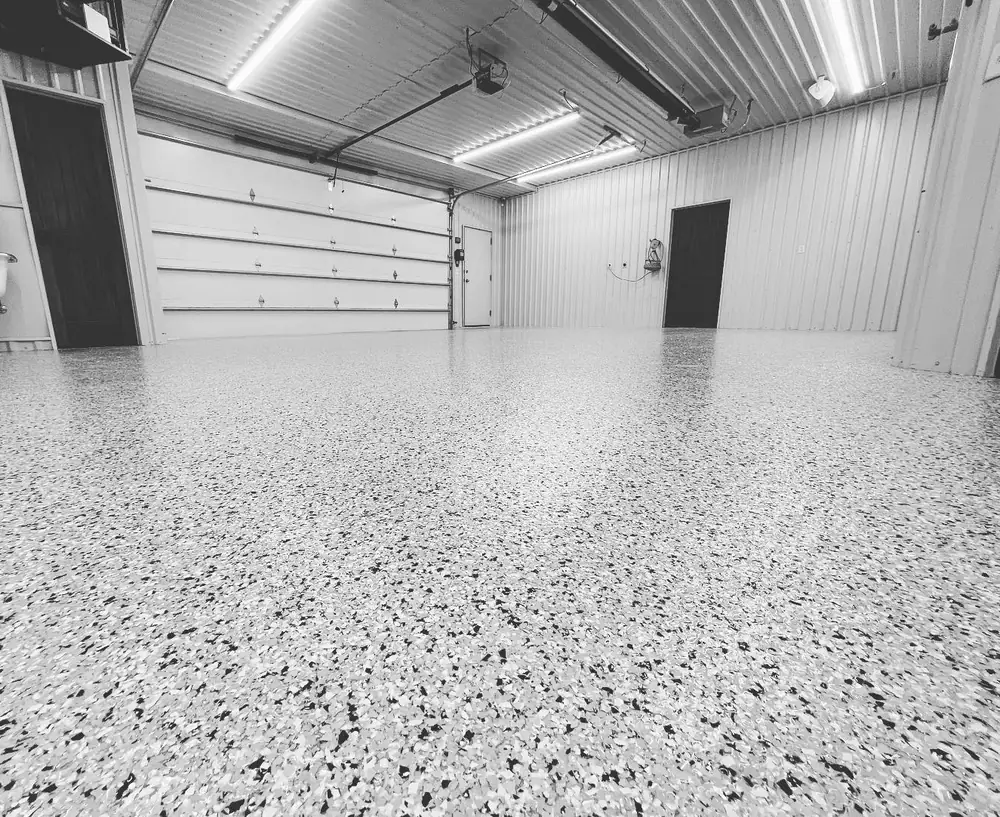 Light gray flake epoxy floor in a shop garage with overhead doors